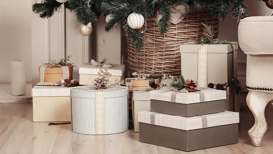 Holiday gift boxes and presents arranged under a Christmas tree for a Boxing Day designer furniture sale