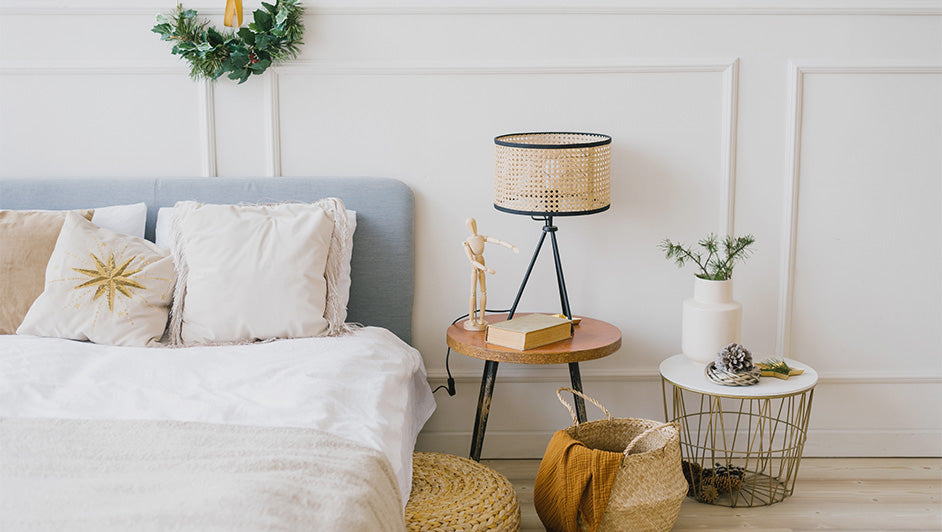Cozy bedroom decor with neutral bedding, a light blue headboard, and a stylish rattan bedside lamp for a serene look.