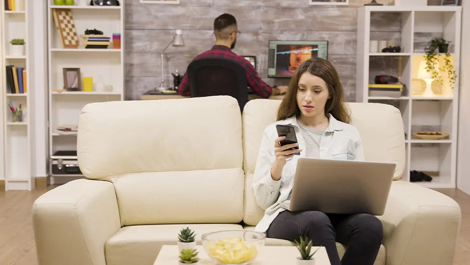 woman browsing furniture online while sitting on a modern sofa in a stylish living room
