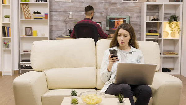 woman browsing furniture online while sitting on a modern sofa in a stylish living room
